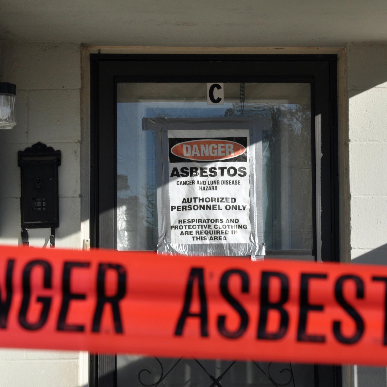 Asbestos warning sign with caution tape